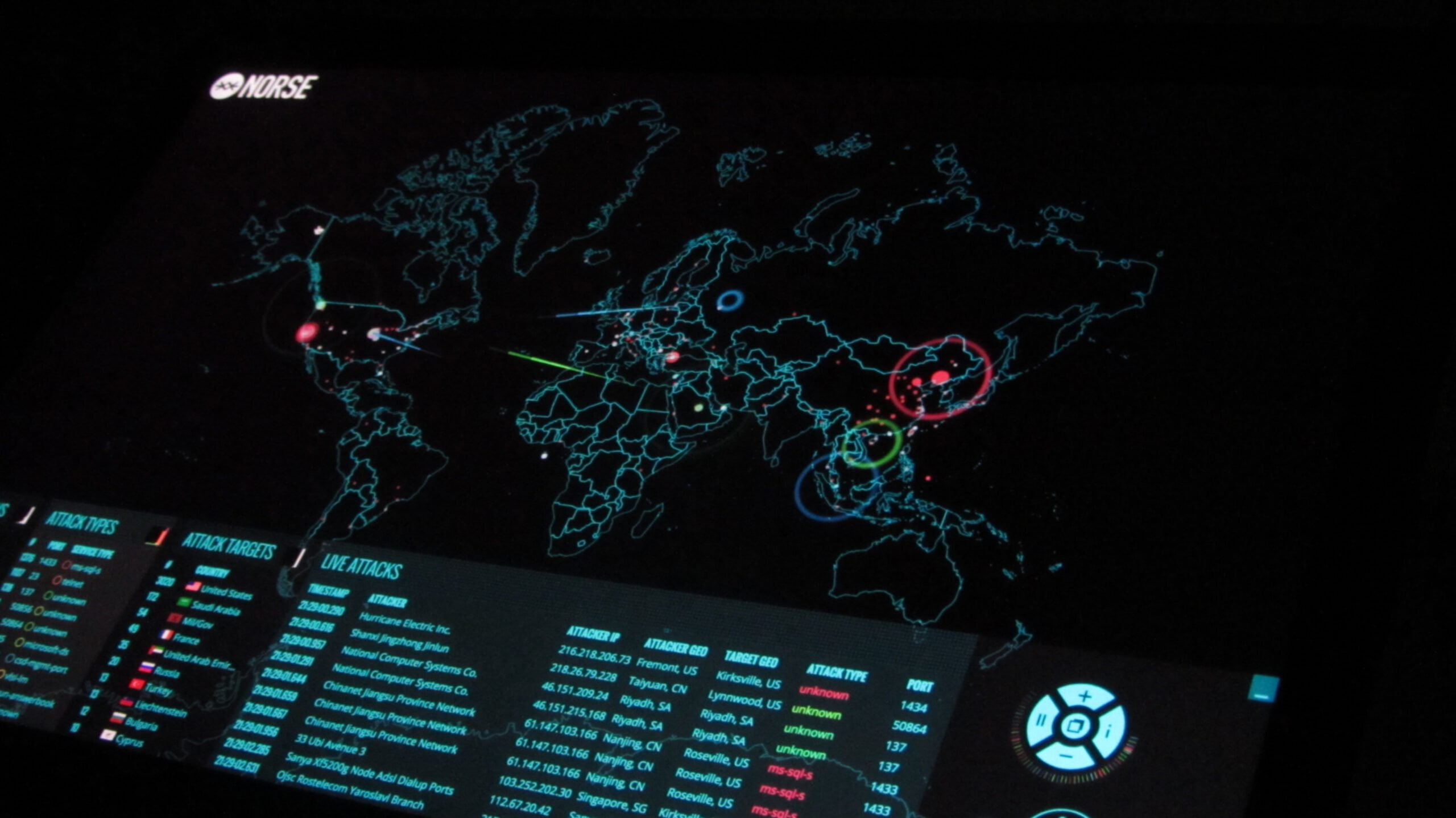 Computer dashboard in digital showing cyber attacks across the world with coloured lines on a map