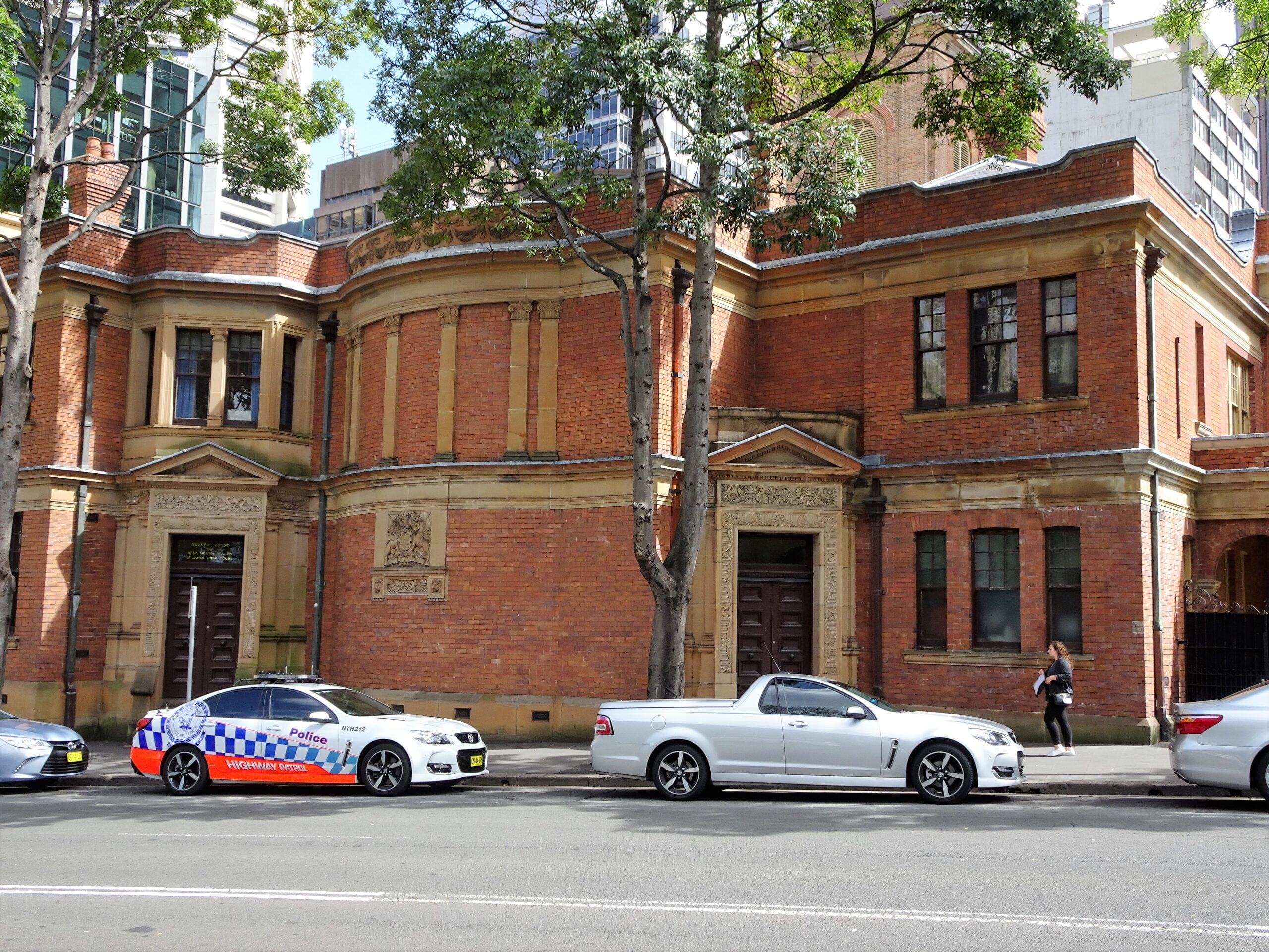 Side of NSW Supreme Court with police car parked out front