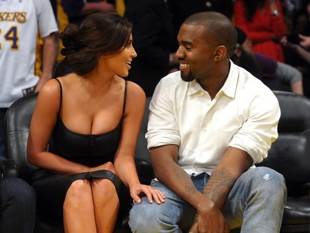 Kim Kardashian and Kanye West at the Basketball, smiling and looking at each other